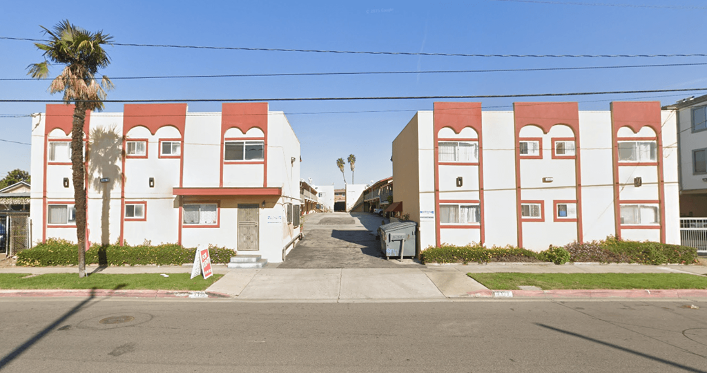 A street view of a row of red and white buildings.