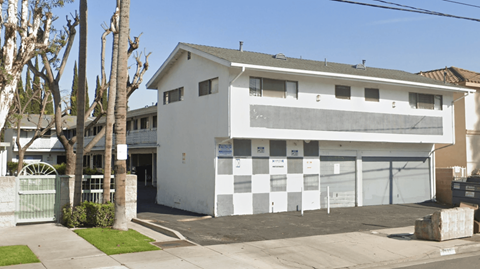 A white two-story house with a garage door and a driveway.