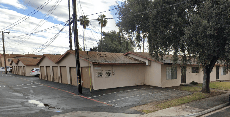 A row of houses with a tree in front of the last one.
