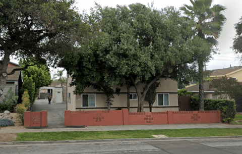 A row of houses with a red fence in front.