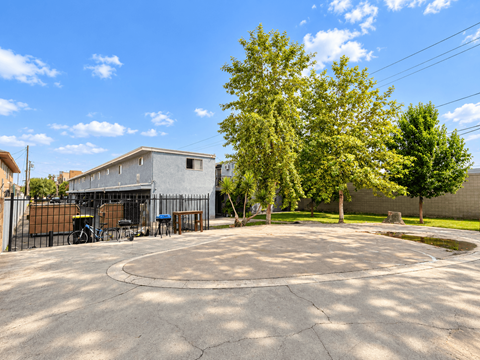 A large, open parking lot with a building and trees in the background.