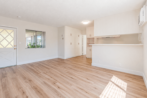 A room with wooden flooring and white walls.