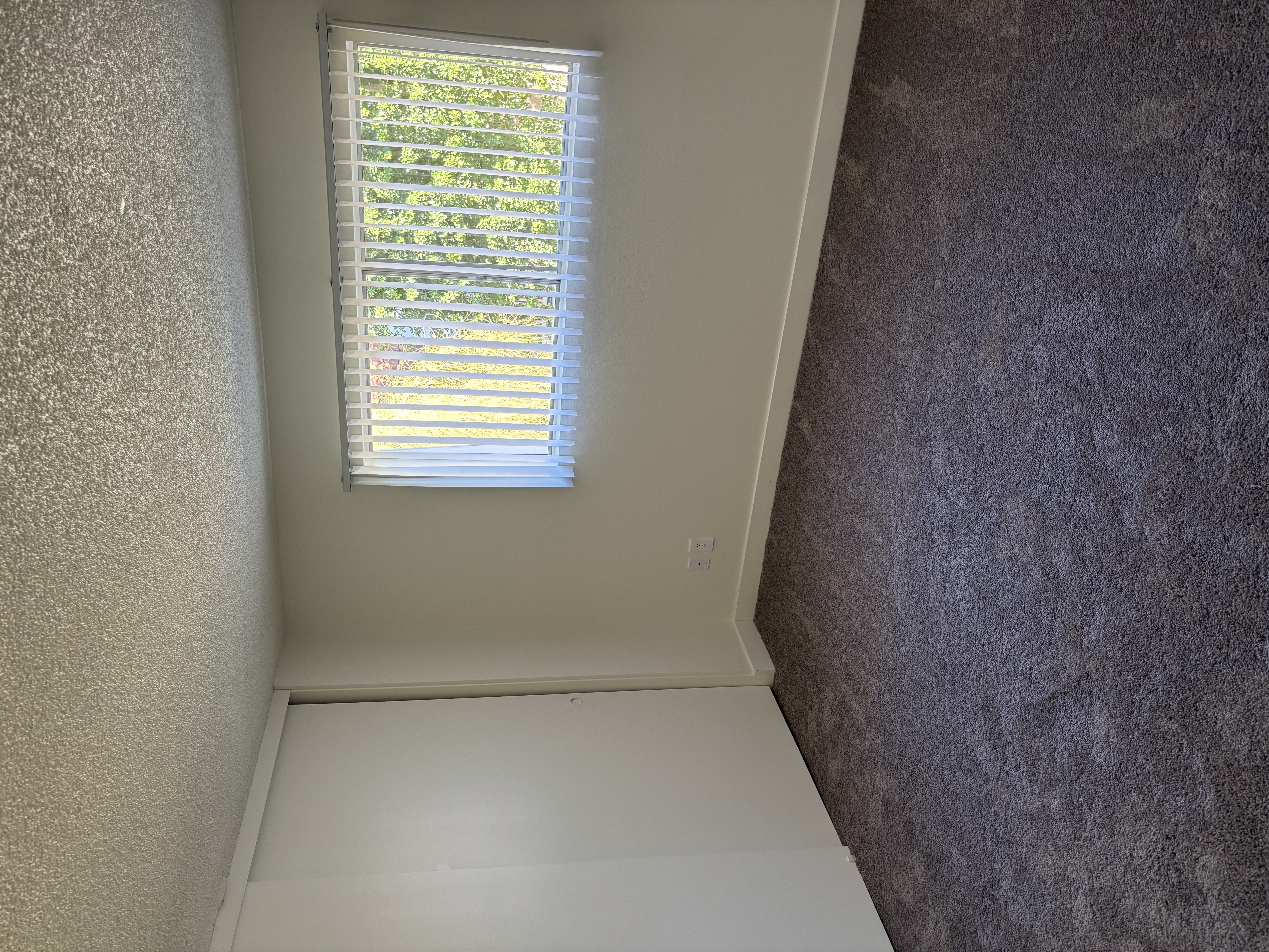 A window with blinds is open, letting in light.