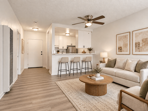 A living room with a white couch, a coffee table, and a ceiling fan.
