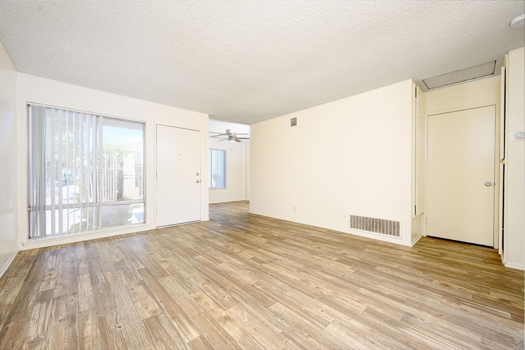 a bedroom with hardwood floors and white walls at Villa Hemet, Hemet