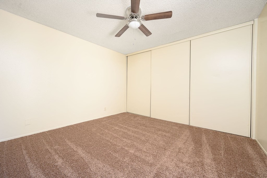 a bedroom with white walls and a ceiling fan at Villa Hemet, Hemet California