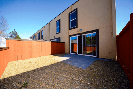 A building with a red fence and a gravel area in front.