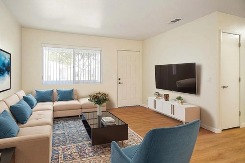 A living room with a sofa, a coffee table, a chair, and a television.