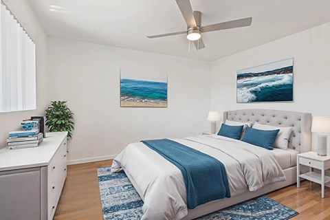 A bedroom with a large bed and a ceiling fan.