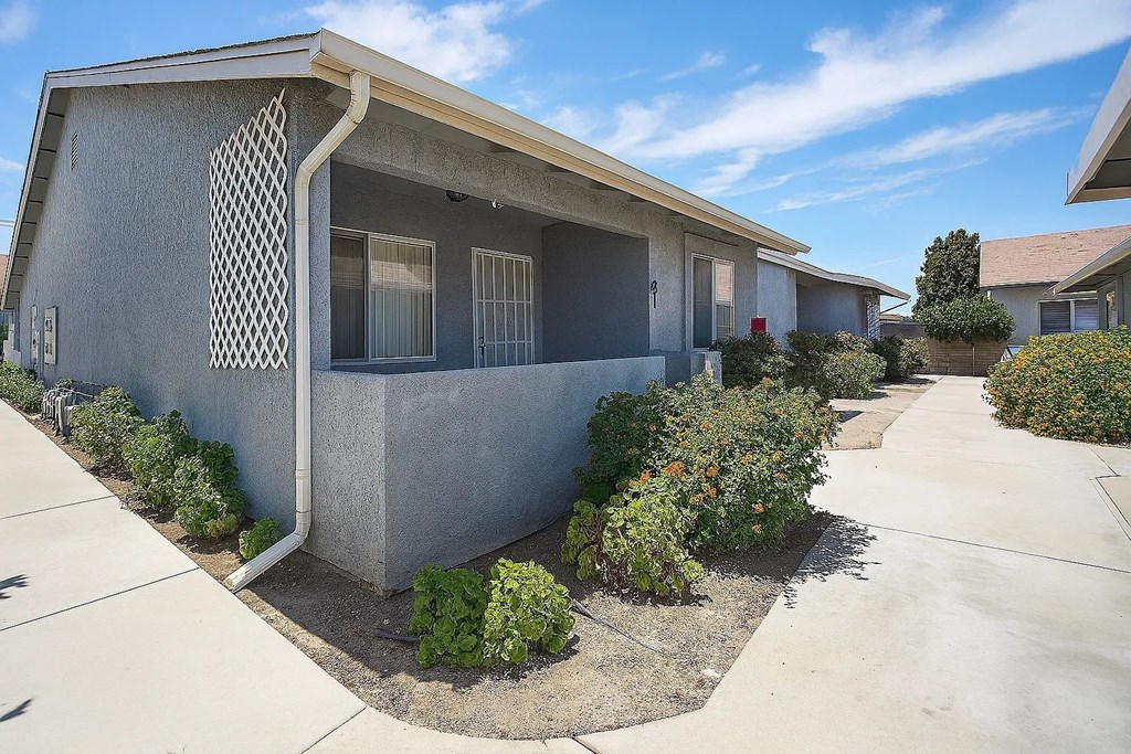 A concrete house with a concrete walkway in front.
