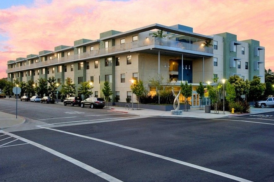 a large apartment building with a parking lot in front of it at Helix at University Village, California