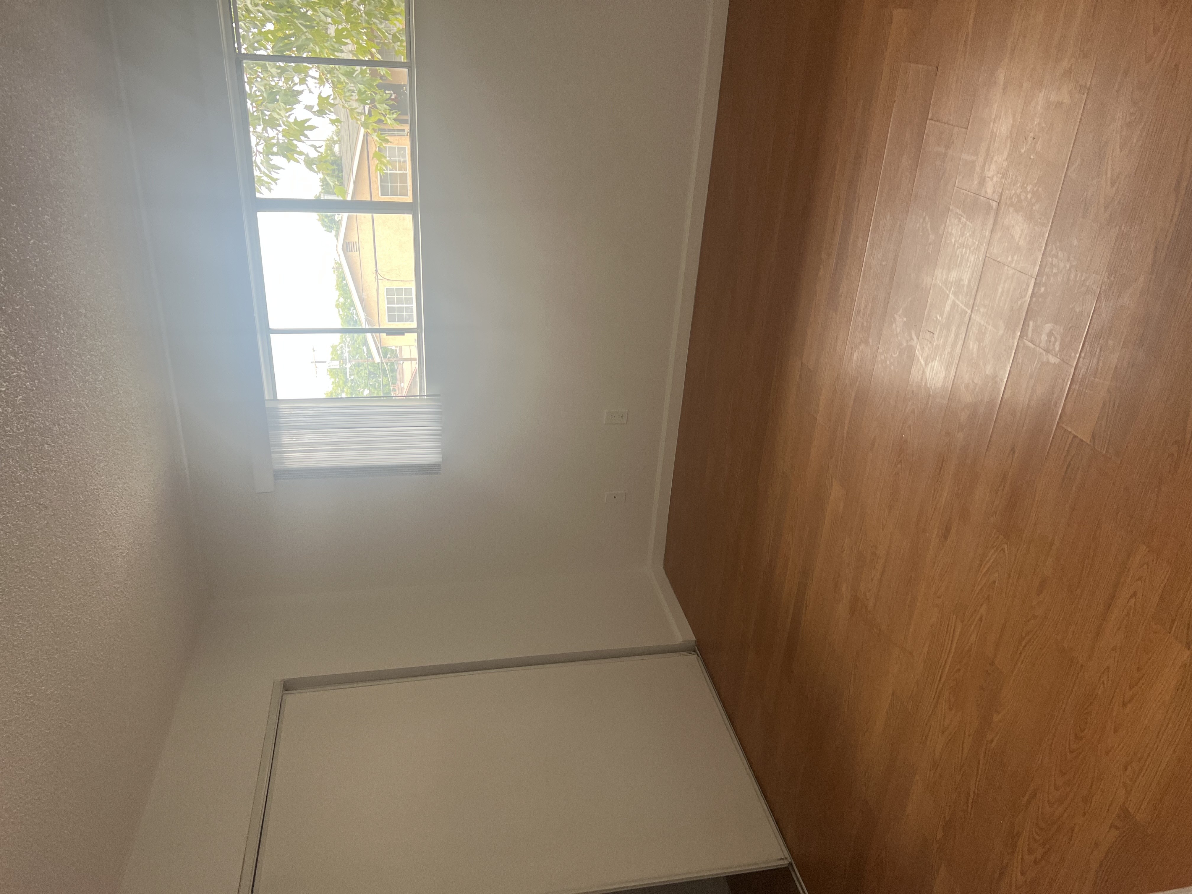A room with a window and wooden walls.