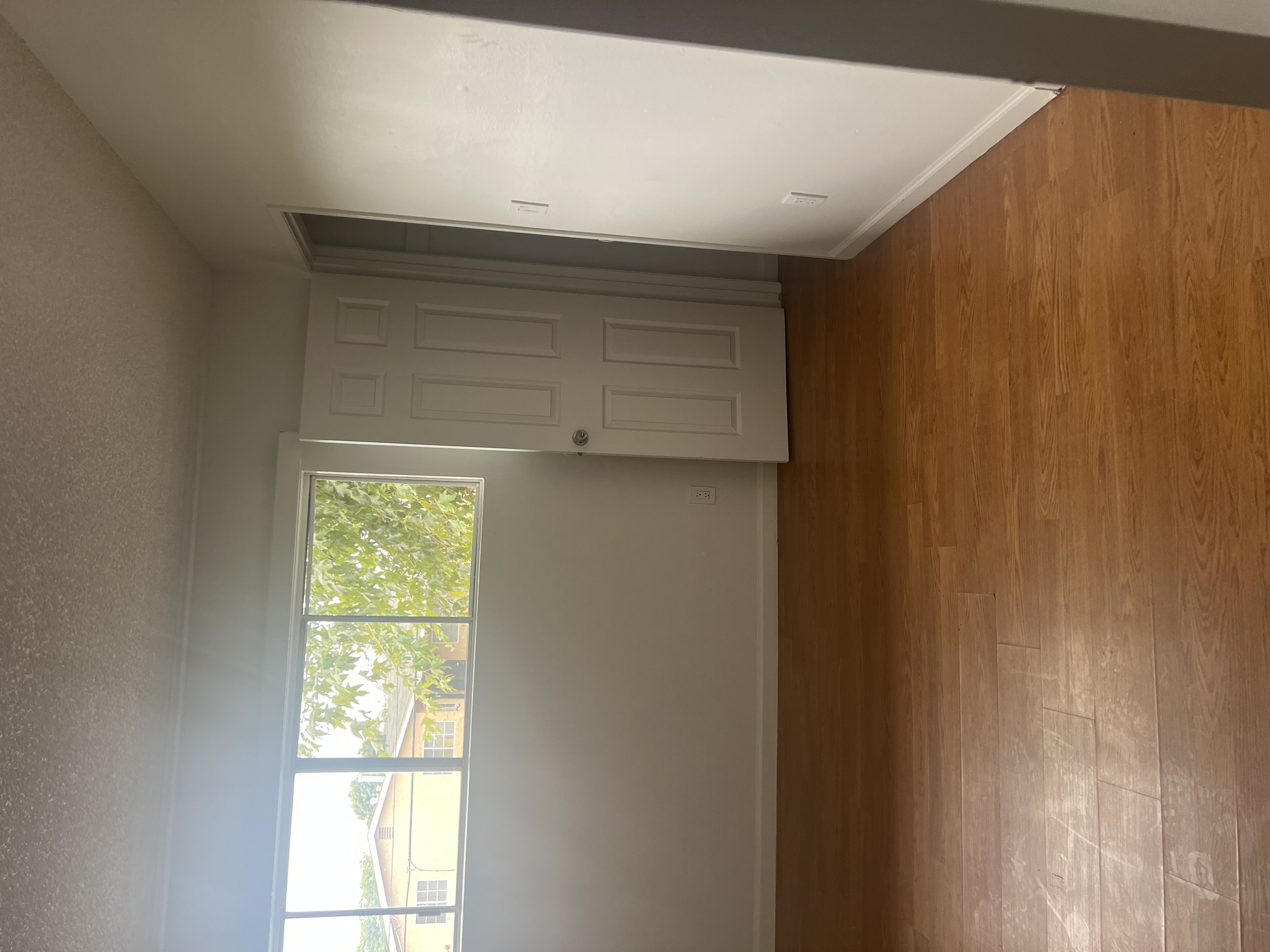 A room with a window and wooden walls.