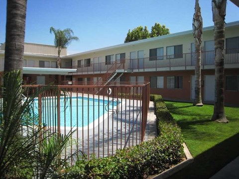A pool surrounded by a fence and trees.