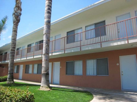 A building with a red and white exterior and a balcony with red railings.