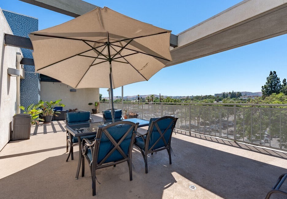 a patio with a table and chairs and an umbrella at Helix at University Village, California, 91766