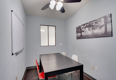 a dining room with a black table and red chairs at Helix at University Village, Pomona, 91766