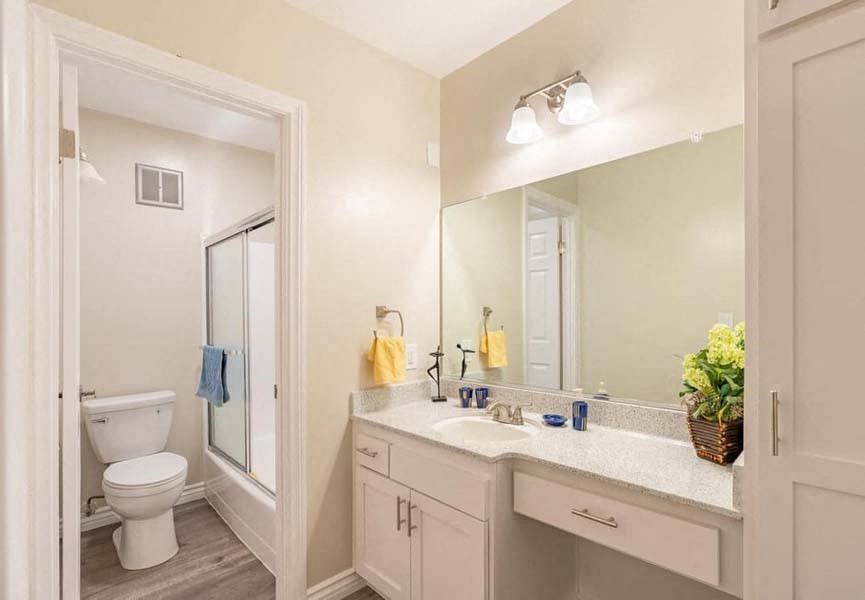 a bathroom with a toilet a sink and a mirror at Mountainview Venture, Covina, CA