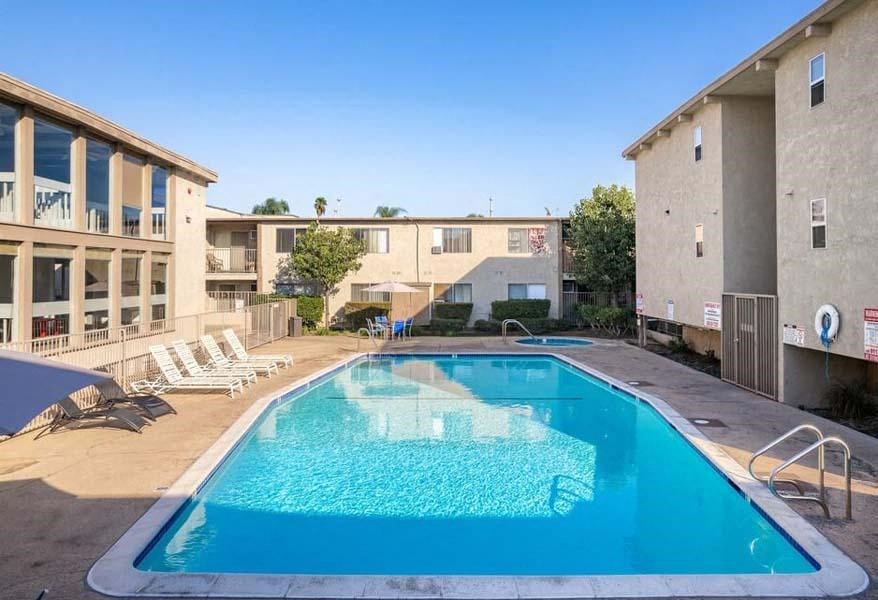 a swimming pool with chaise lounge chairs and a building in the background at Mountainview Venture, California