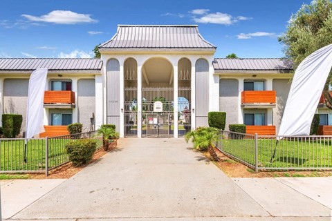 a white building with a walkway and a gate at Sunnymead Apts Apartments, California