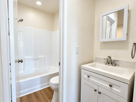 A white bathroom with a toilet, sink, and bathtub.