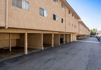 an empty parking lot in front of a brick building at North View Terrace, California, 90640