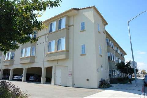 A building with a parking garage in front.