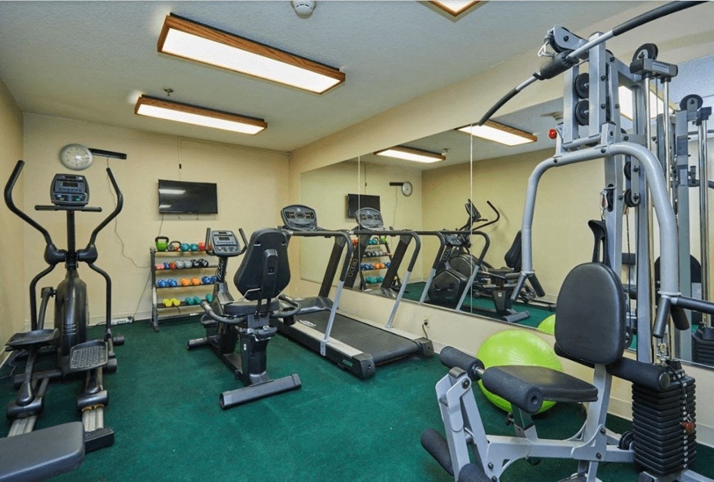 a gym with weights and other exercise equipment in a home gym at Huntington Terrace North Senior, Huntington Beach, CA 92648