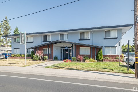 A street view of a residential area with houses and cars.