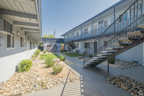 A long black metal staircase leads up to a balcony.