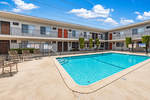 A swimming pool in front of apartment buildings.