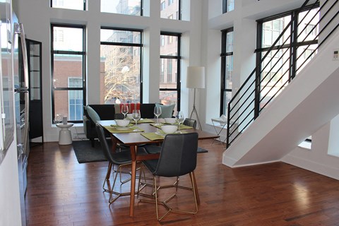 a dining room with a table and chairs and a staircase