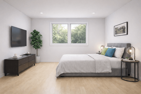 Modern bedroom with gray upholstered bed and natural light at The Maddox Apartments, Trenton, NJ