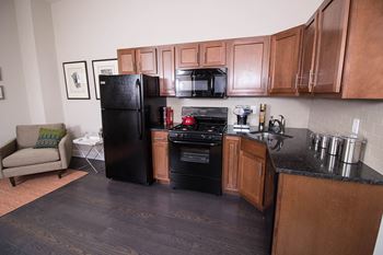 A kitchen with black appliances and wooden cabinets.