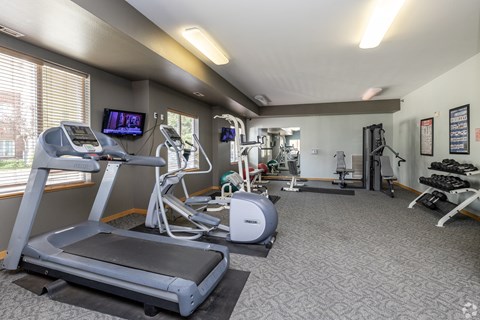 A gym with treadmills, elliptical machines, and other exercise equipment.