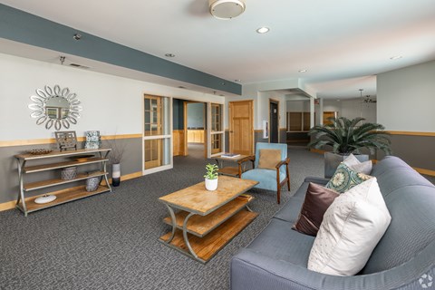 A living room with a grey couch and a wooden coffee table.