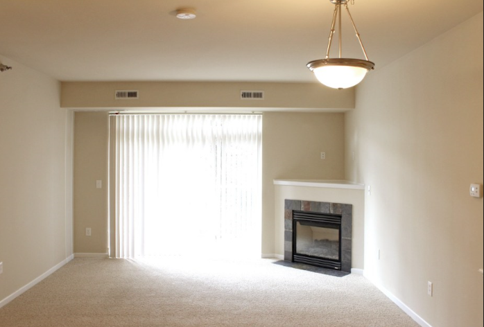 a living room with a fireplace and a large window