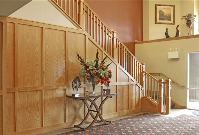a wood paneled stairway with a table with a vase of flowers on it