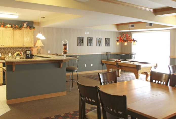 a community room with a pool table and dining table