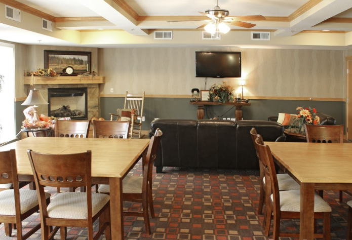 a room with large tables and chairs and a television on the wall