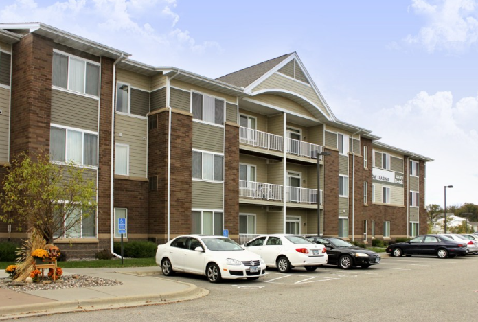 a large apartment building with a parking lot in front of it
