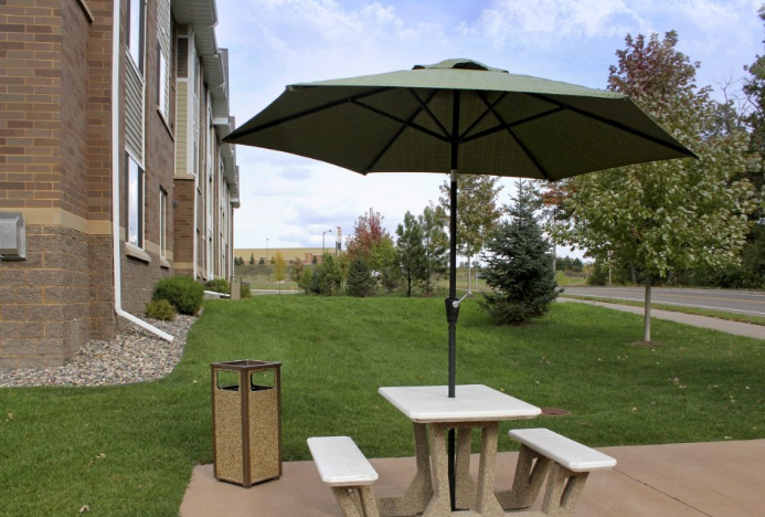 a picnic table with an umbrella and benches on a patio