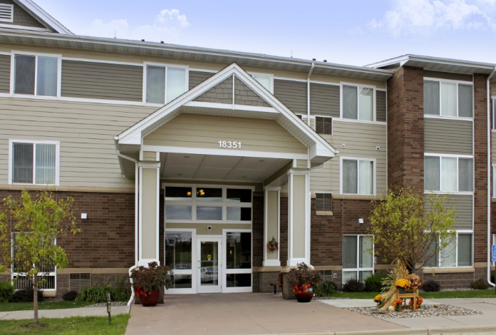 a large brick building with a porch and a walkway in front of it