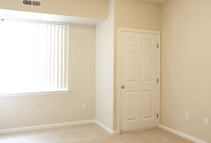 an empty bedroom with a window