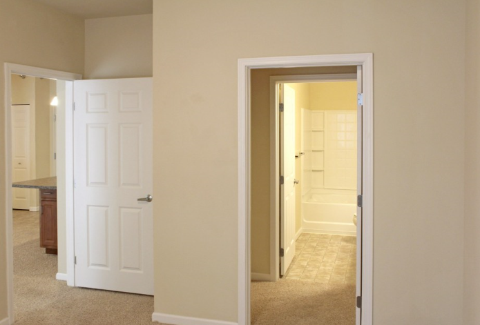 a view from the living room into the bathroom and the bedroom