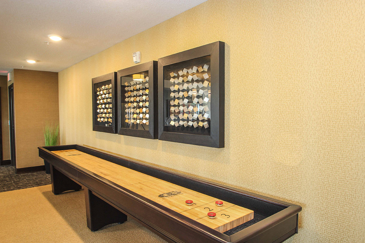 a community room with a shuffleboard table at The Flats at Cedar Grove, Eagan, MN