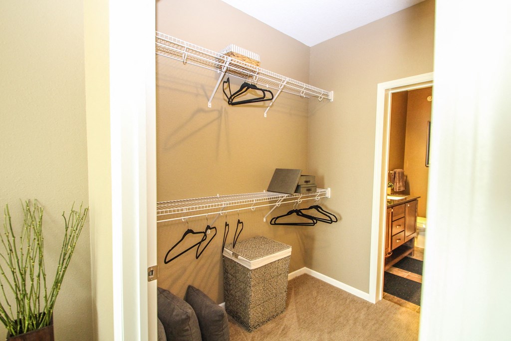 a walk in closet in a bedroom with a door to a bathroom at The Flats at Cedar Grove, Minnesota