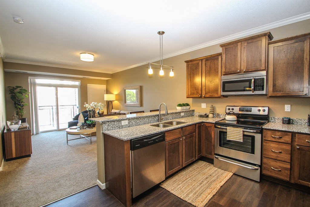 a kitchen with wooden cabinets and stainless steel appliances at The Flats at Cedar Grove, Eagan, 55122