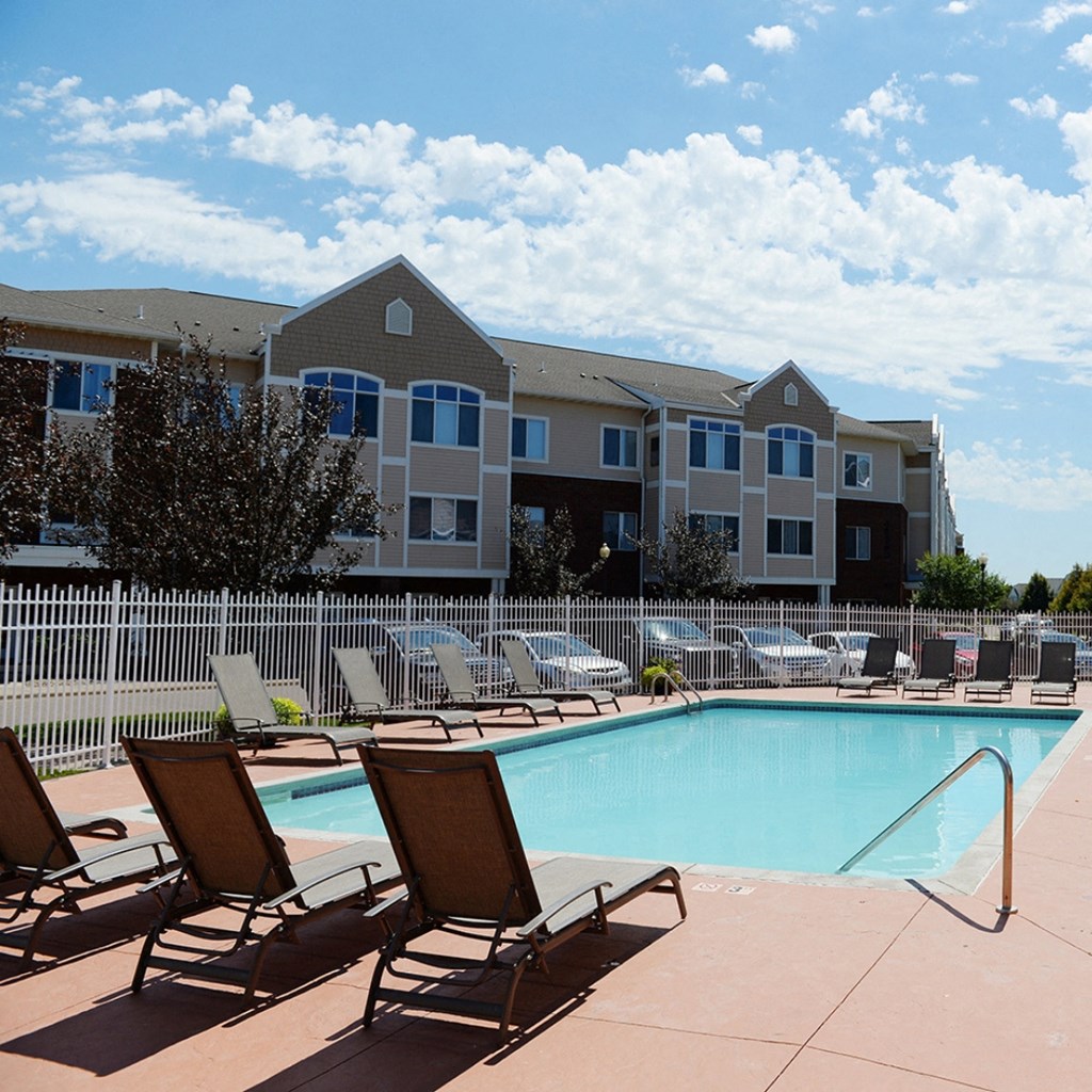 a swimming pool with lounge chairs at Hearthstone Apartments and Townhomes, Minnesota