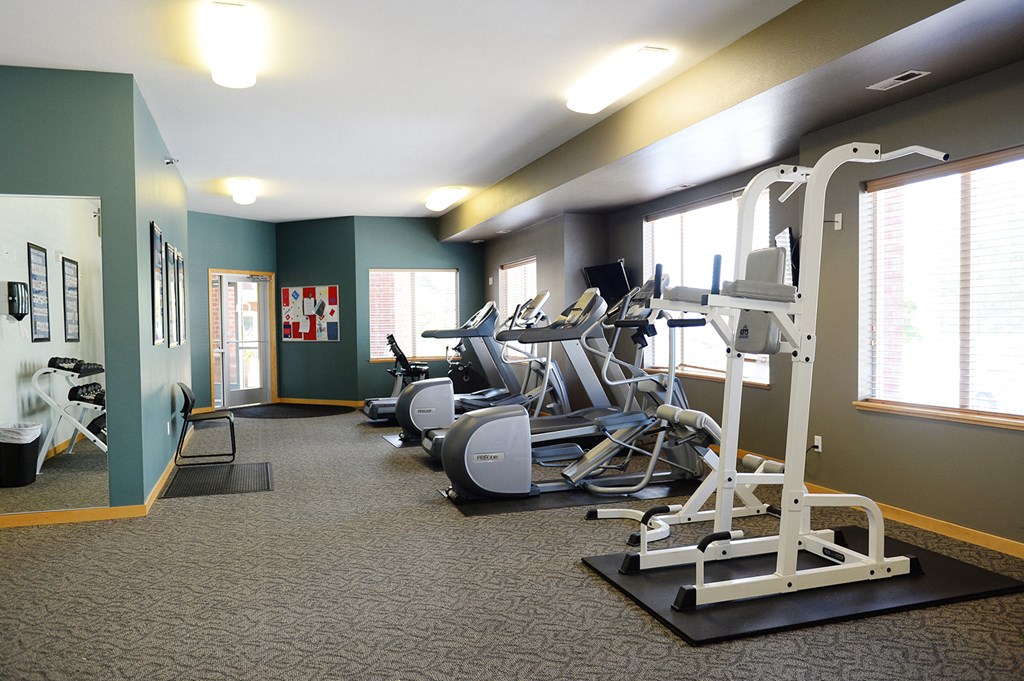 a fitness room with various exercise equipment in it at Hearthstone Apartments and Townhomes, Apple Valley